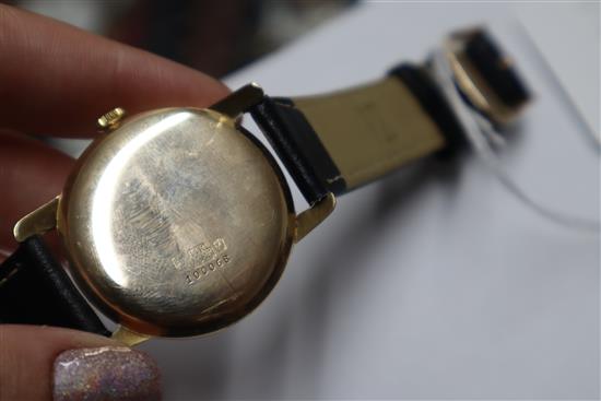 A gentlemans 14k Huguenin manual wind wrist watch, on associated leather strap.